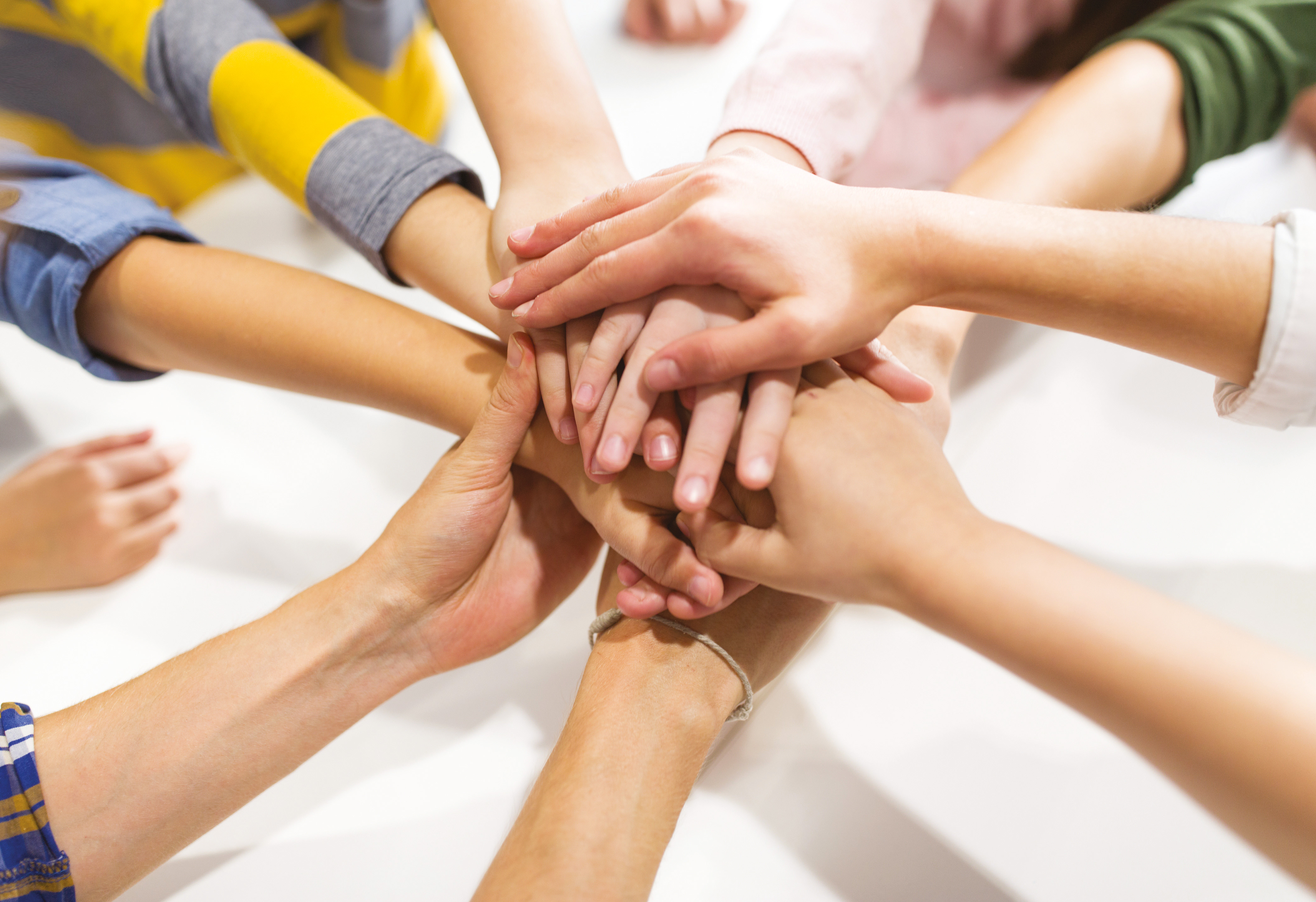 group of kinds with hands on top